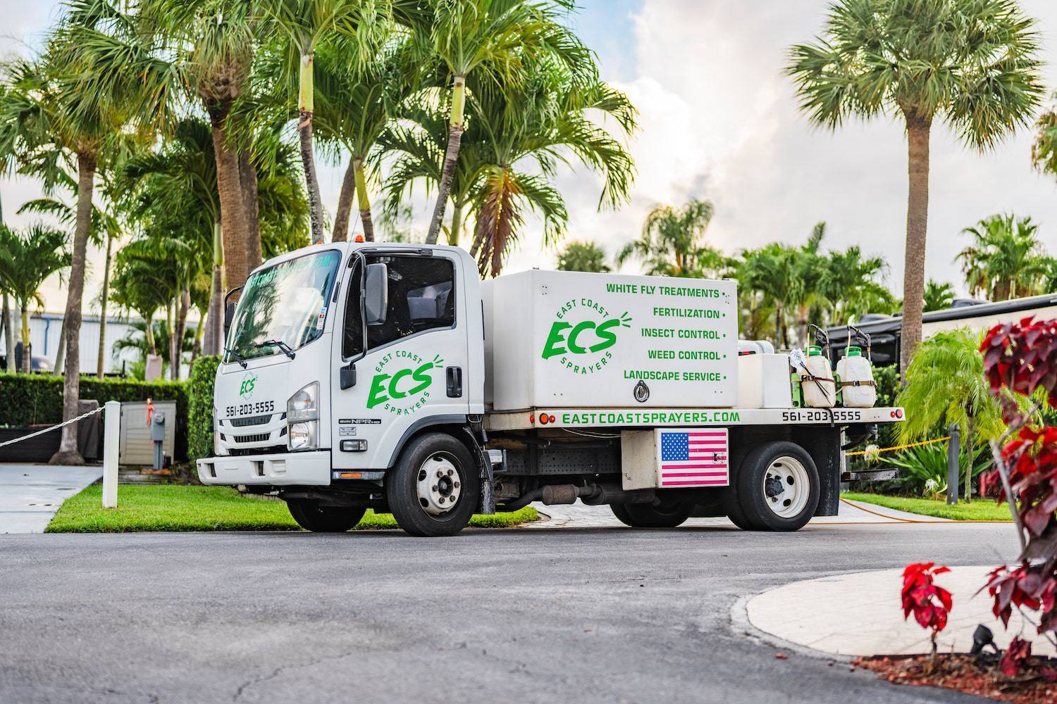 Commercial lawn maintenance near me service spraying turf and planting beds in Boca Raton, FL